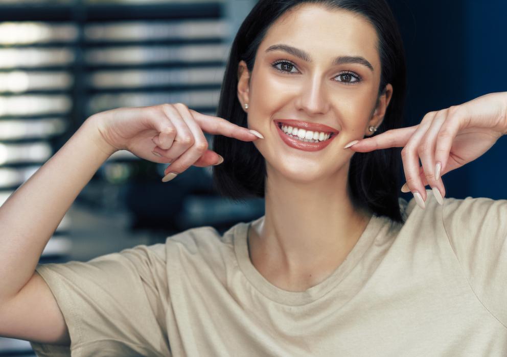 A smiling woman showing off her new veneers