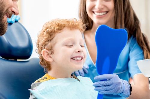 A dentist showing a young child their new smile