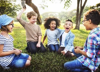 A group of children sitting in a circle on the grass