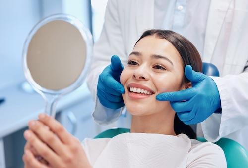 A dentist showing a patient her porcelain veneers