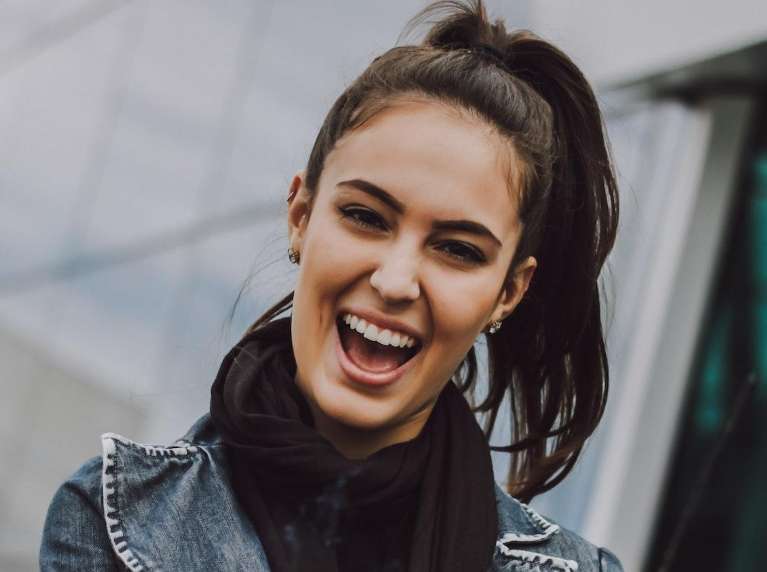 A laughing woman outside of an office building