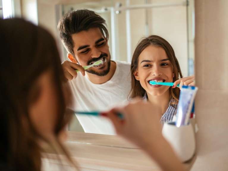 A couple brushing their teeth together