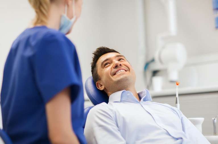 A smiling man talking to his dentist