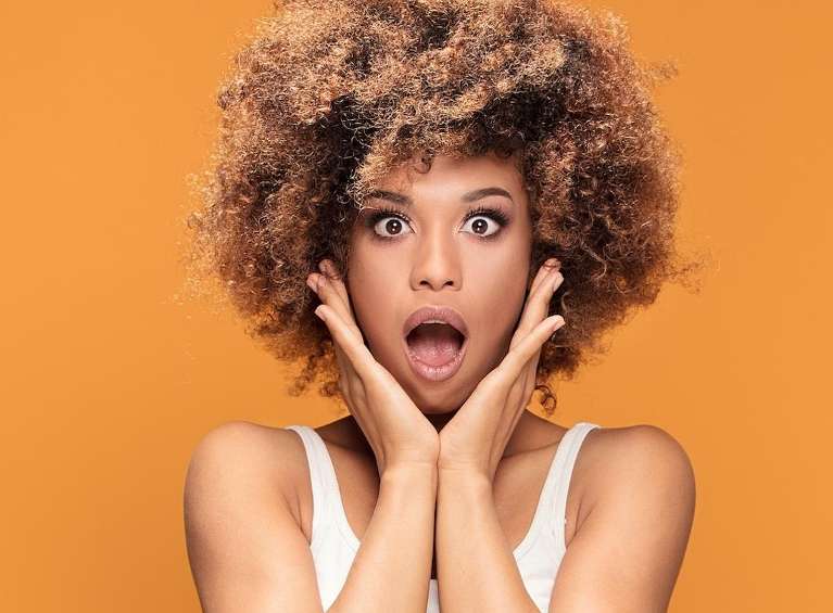 A shocked woman with an orange background