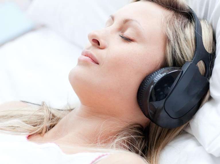A sleeping woman wearing noise-cancelling headphones